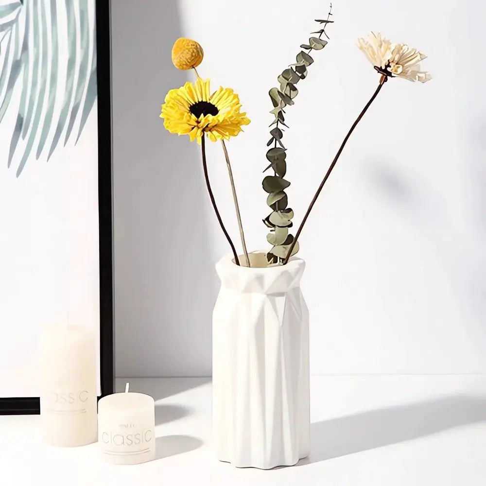 Nordic plastic vase with geometric white finish holding dried yellow flower bouquet and eucalyptus stems