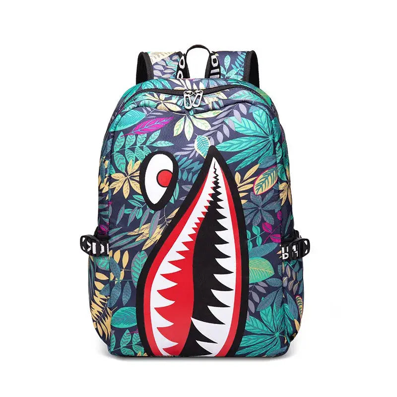Backpack by Simples Market with a bold cartoon shark mouth print over a tropical leafy pattern, perfect for kids.