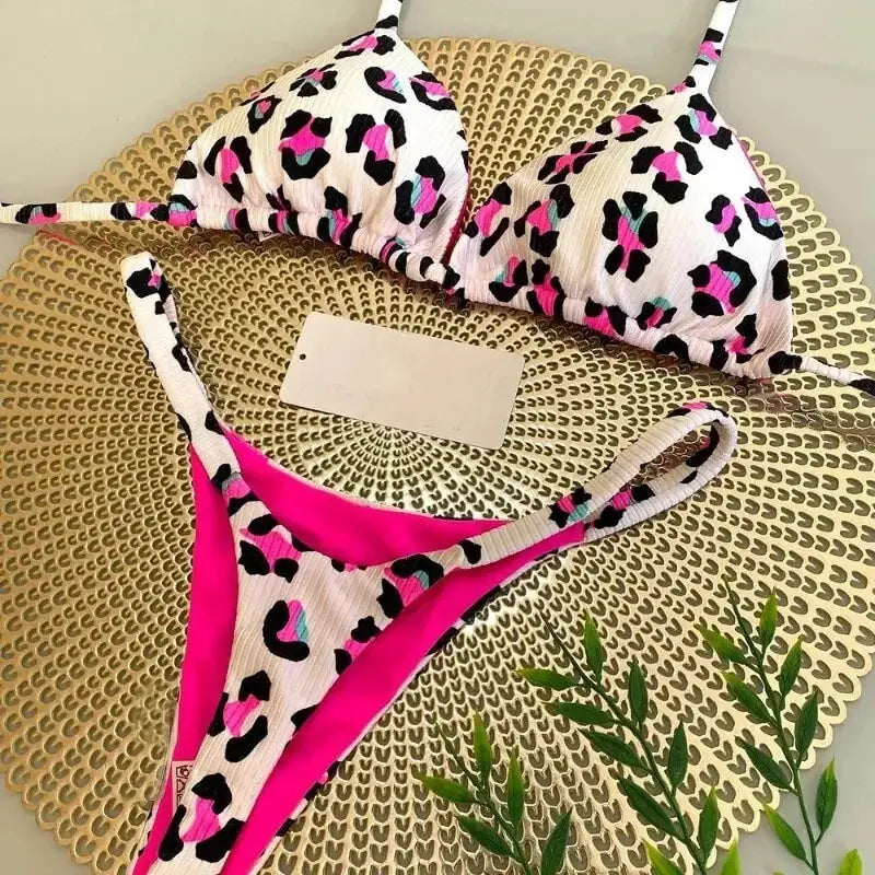 Simples Market two-piece bikini set in white leopard print with pink accents; triangle top and G-string bottom