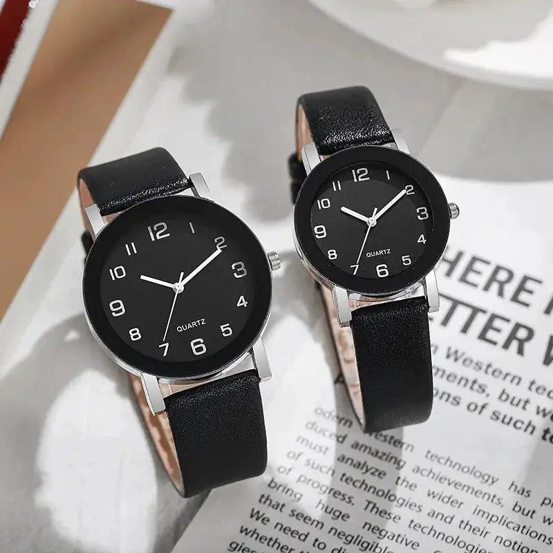 Two black-dial quartz watches with leather straps and silver-tone cases for men and women