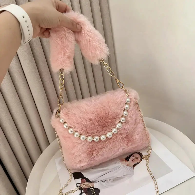Pink rabbit fur handbag with pearl bead strap and gold chain crossbody.