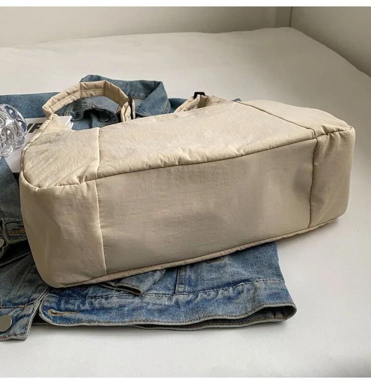 Beige women's soft-cloth shoulder bag, large Y2K casual crossbody style on denim jacket.