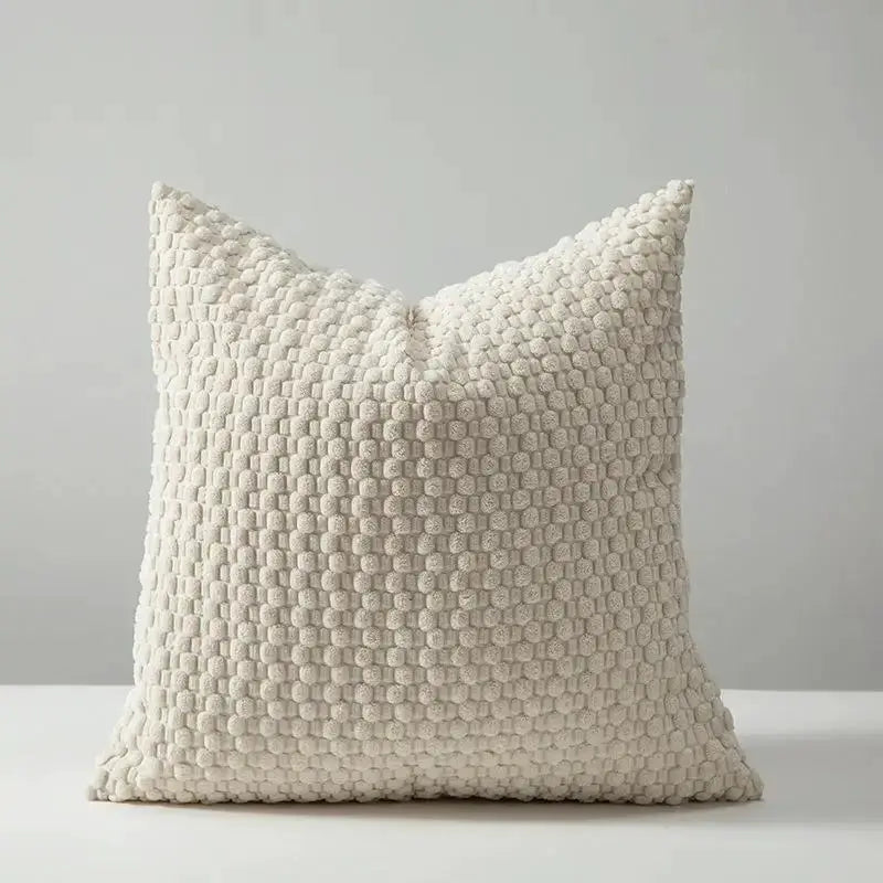 Sofa cushion cover in cream with a chunky knit textured surface.