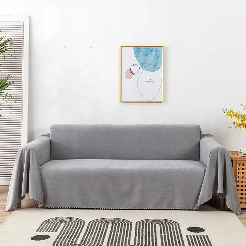 Waterproof sofa cover in solid grey draped over a living room sofa, dustproof and durable.