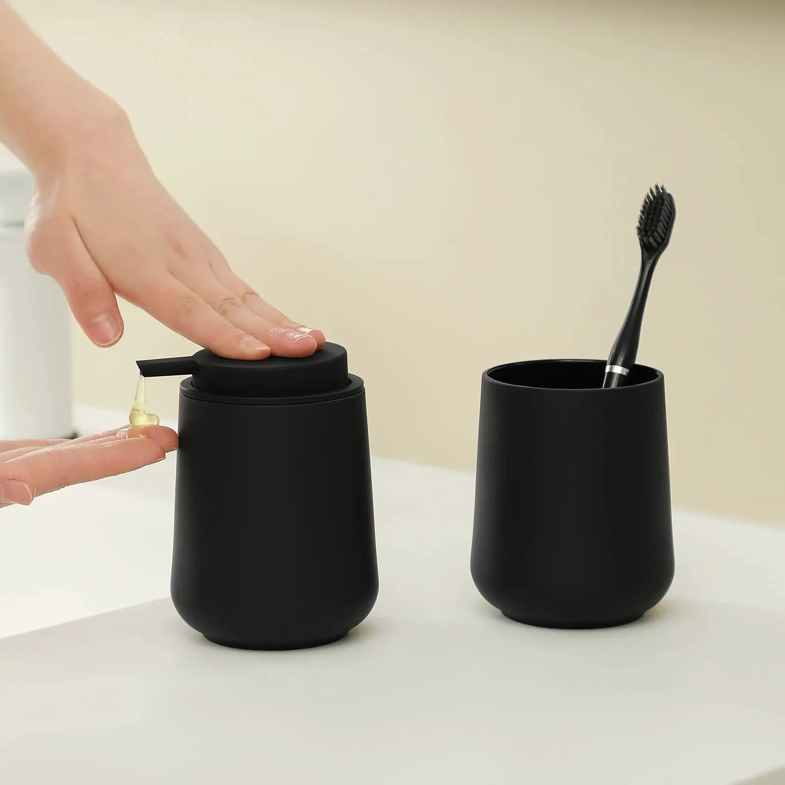 Bathroom accessory set: 2-piece matte black soap dispenser and toothbrush cup.