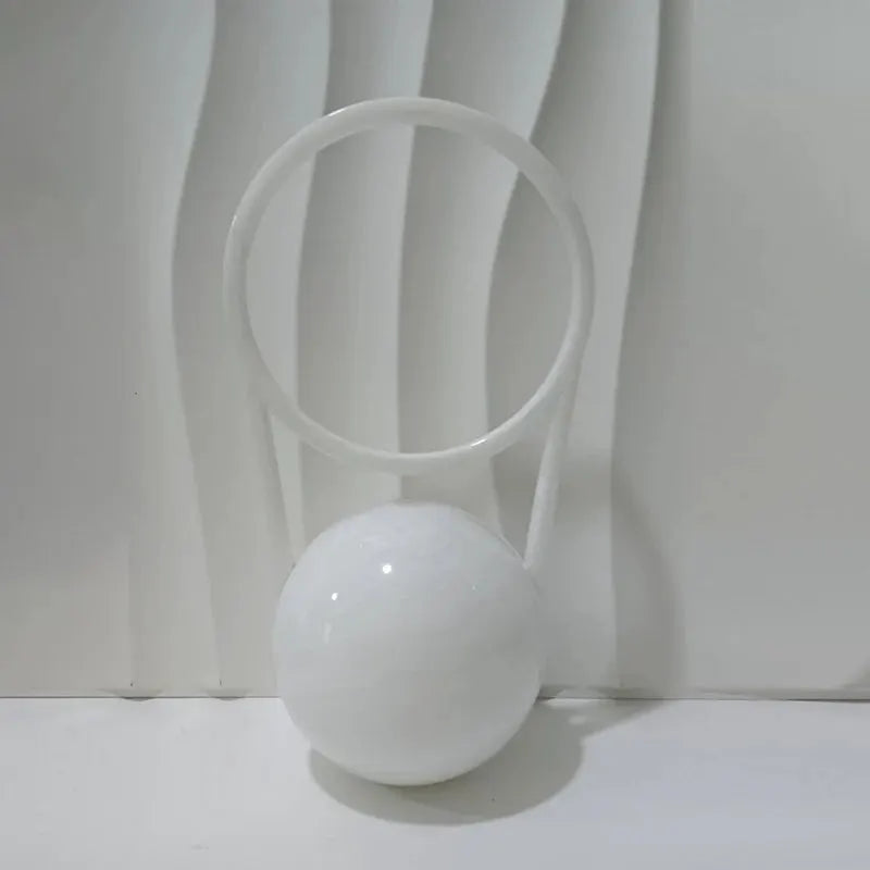 White acrylic evening clutch with ball handle and circular ring.