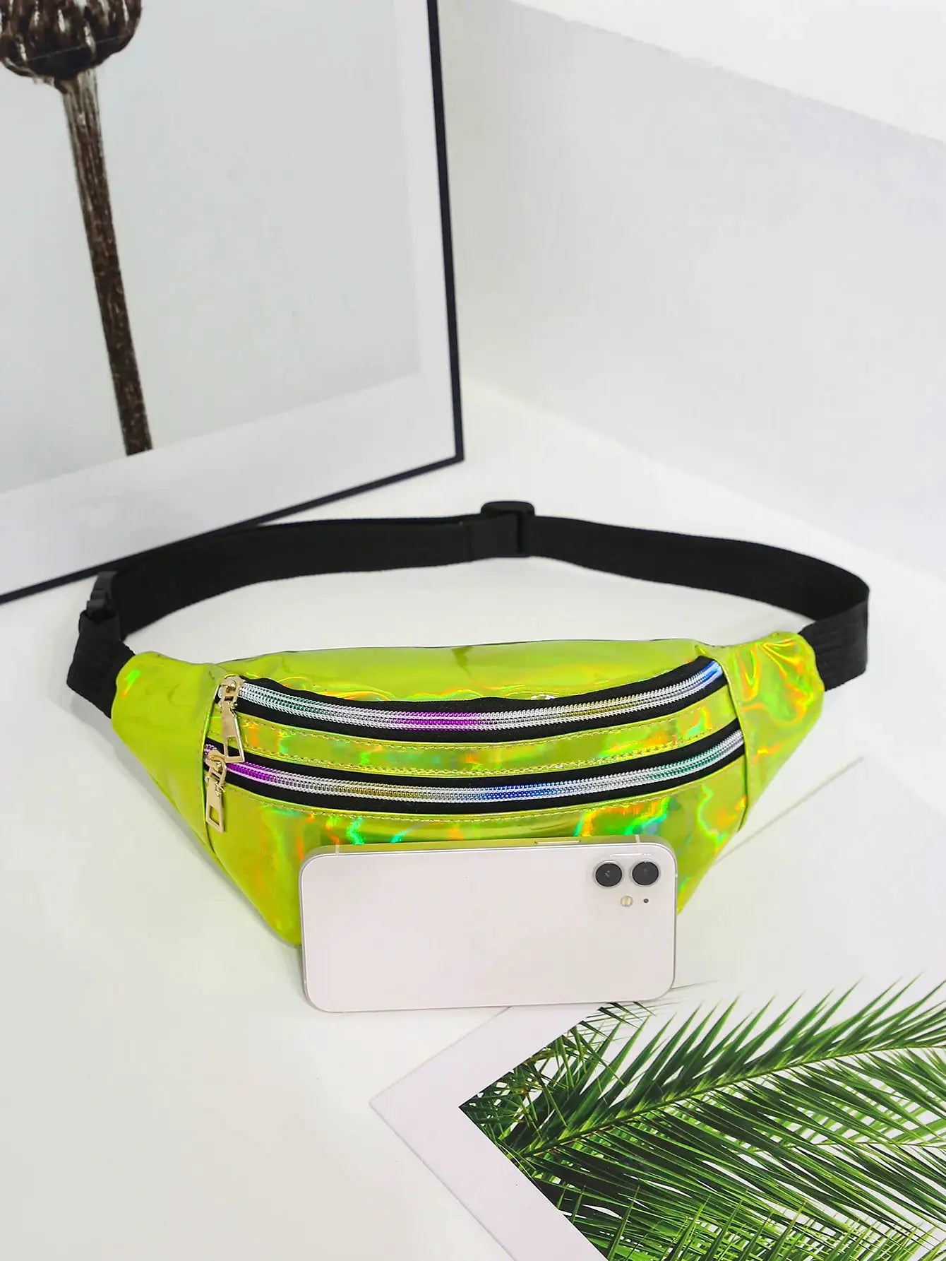 Holographic fanny pack with neon lime PU, three zip pockets, and a black adjustable belt.