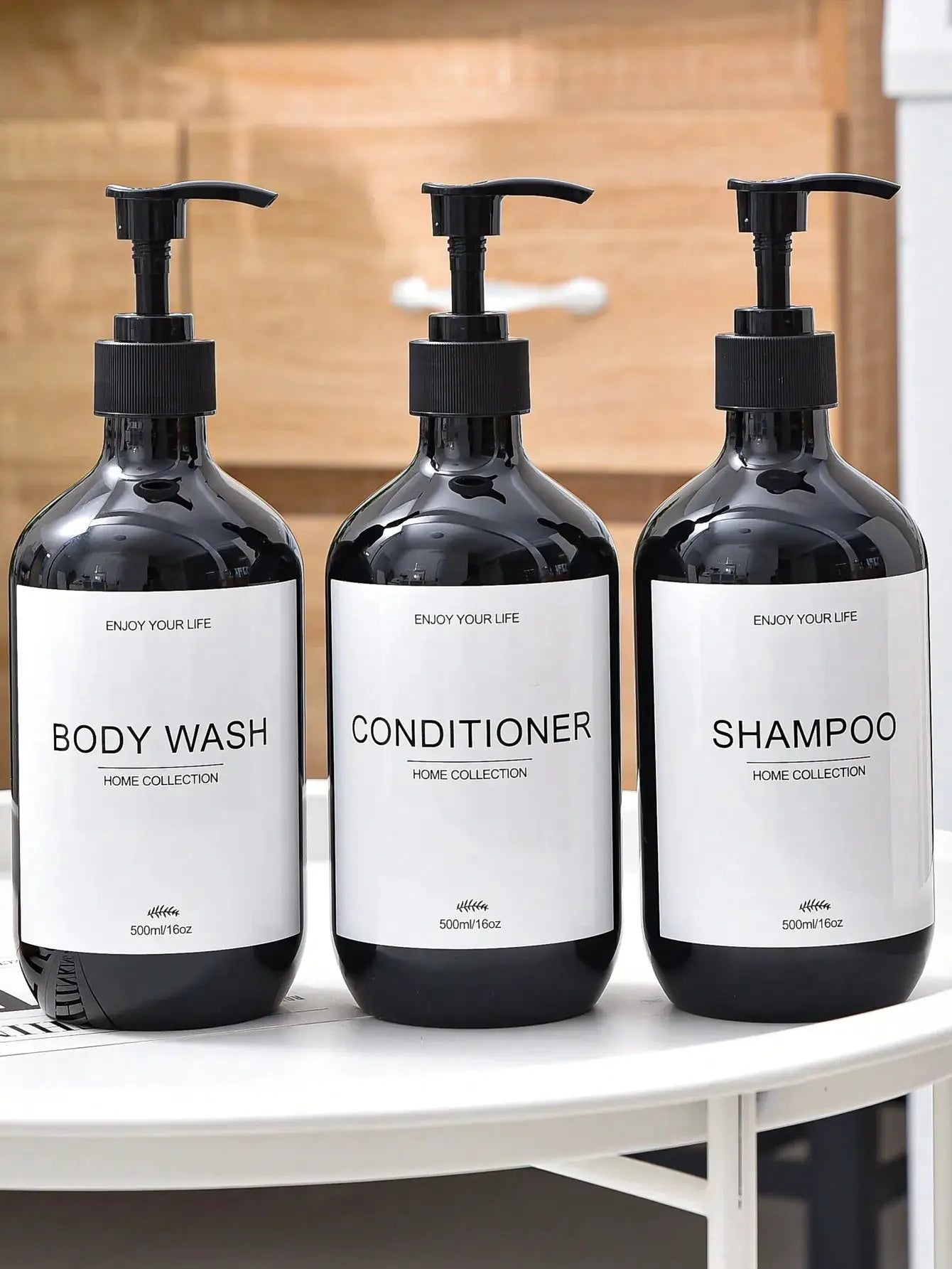 Set of three black pump dispenser bottles with white labels for Shampoo, Conditioner, and Body Wash (500ml/16oz)