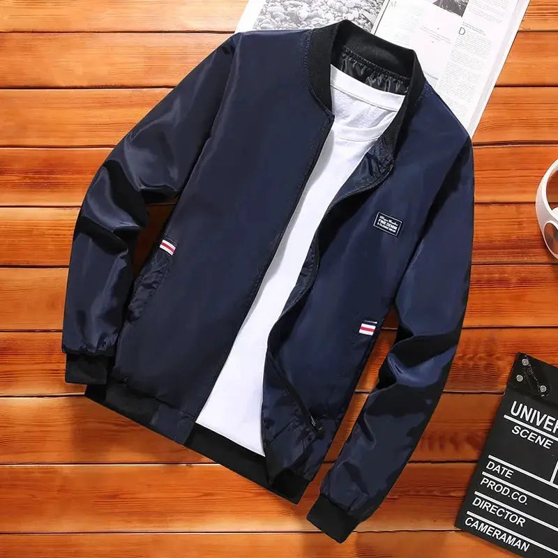 Men's navy lightweight windbreaker jacket with zip front, side pockets, and ribbed cuffs