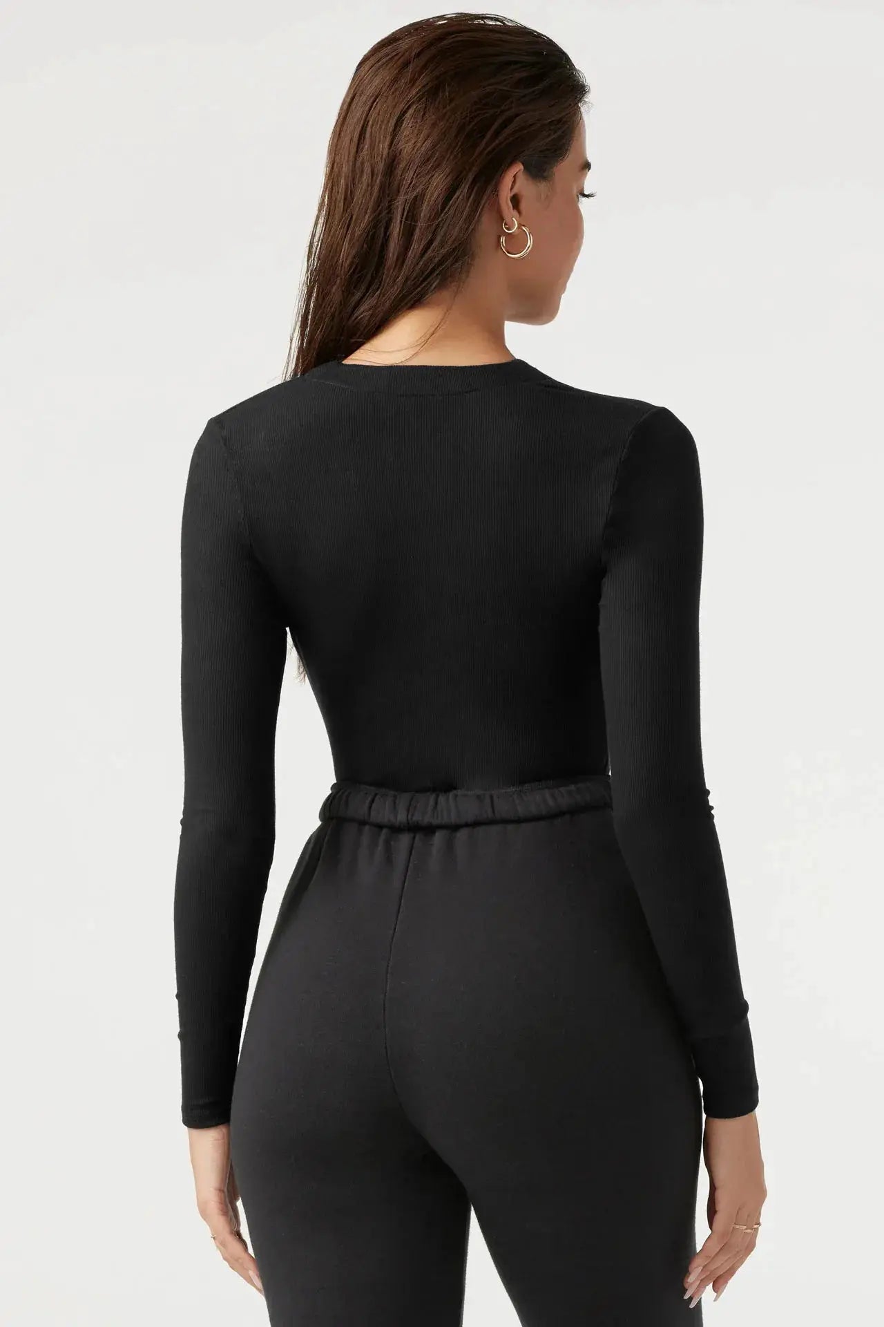 Women's black ribbed knit fitted jumpsuit back view with long sleeves and elastic waistband