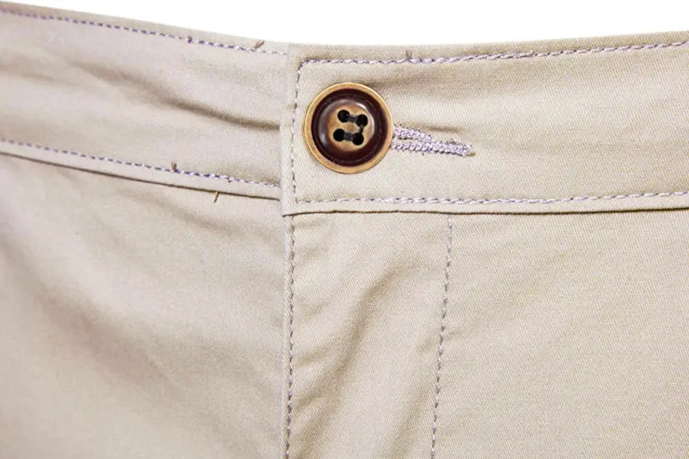 Beige men's cotton shorts with button waist closure; close-up of waistband detail.