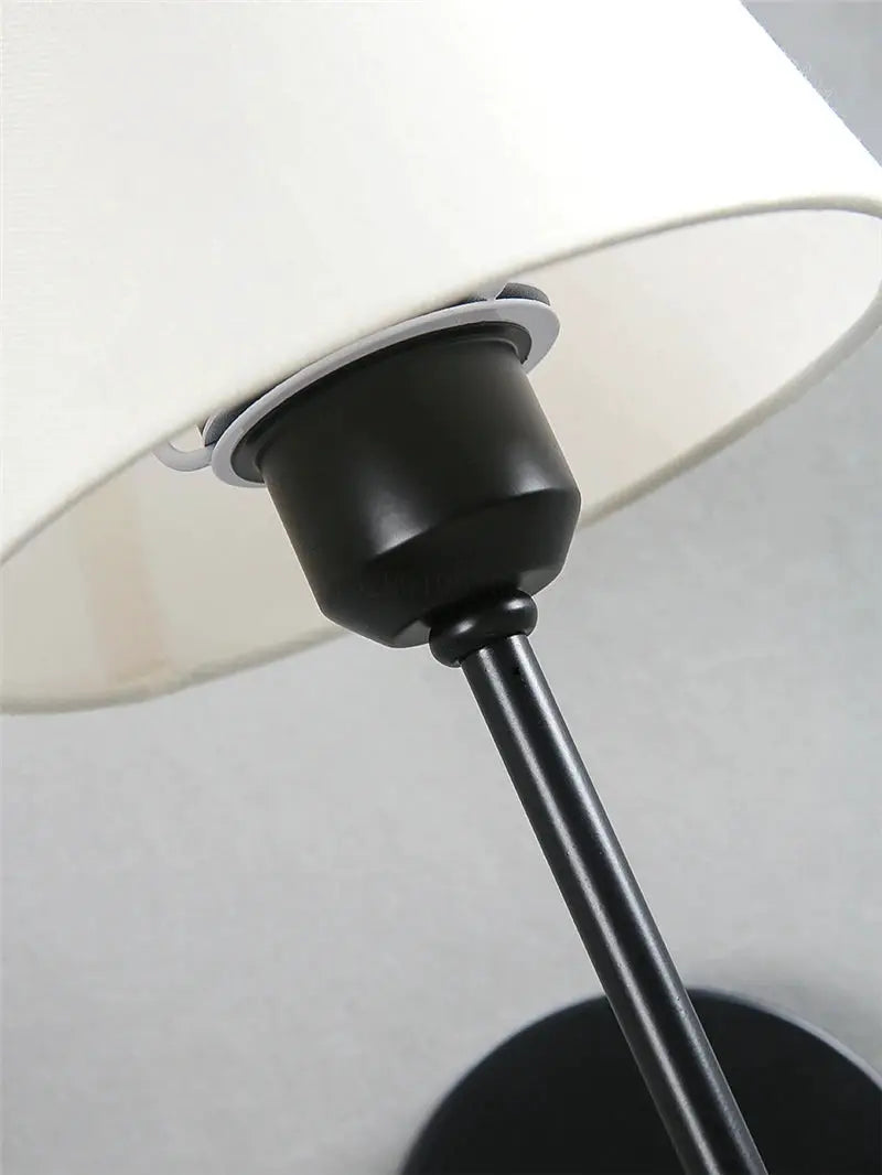 Modern American wall lamp by Simples Market with cloth shade and black metal stem.