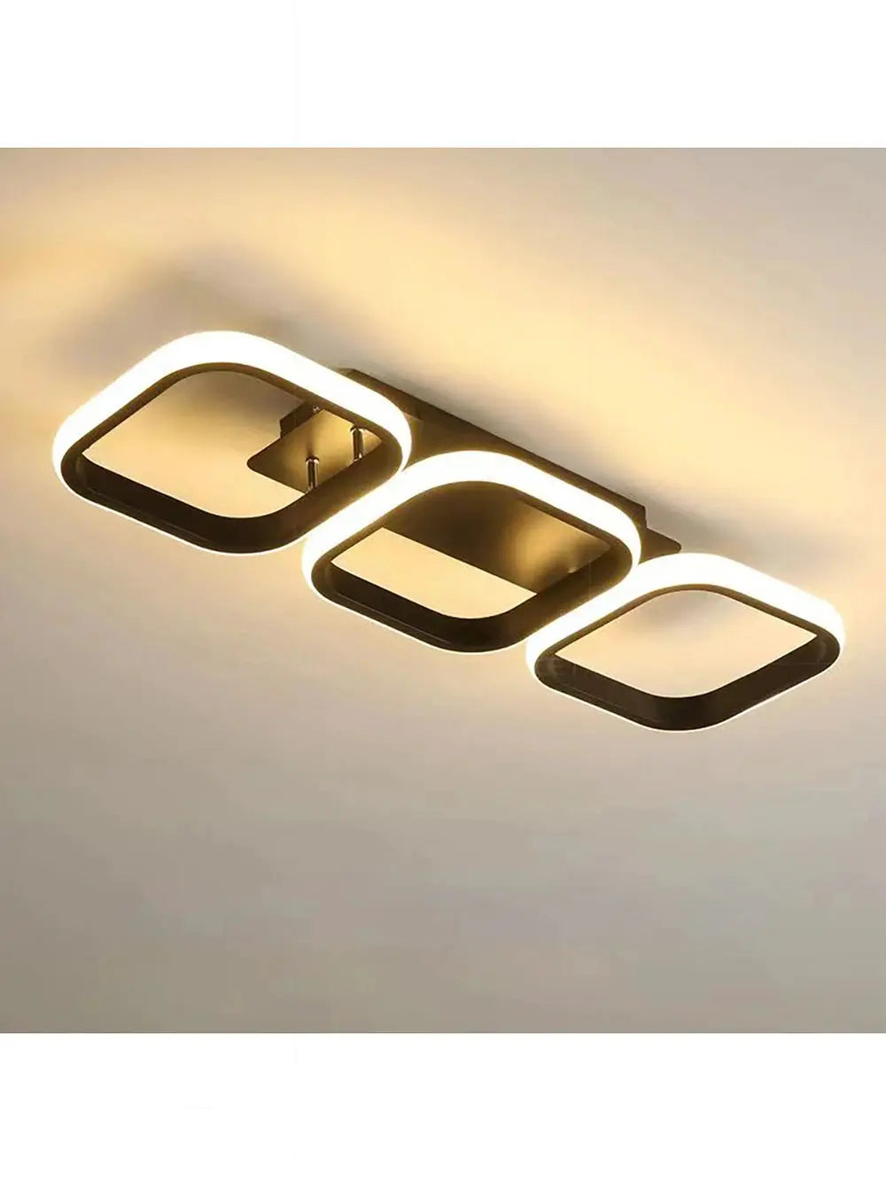 LED ceiling light by Simples Market; three interconnected rounded-square rings in dark bronze with warm LED glow