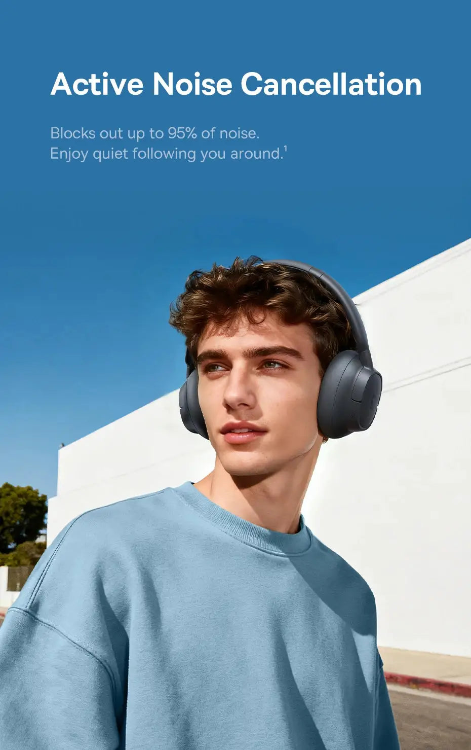 Baseus Bass EH10 NC wireless over-ear headphones in gray worn by a model outdoors