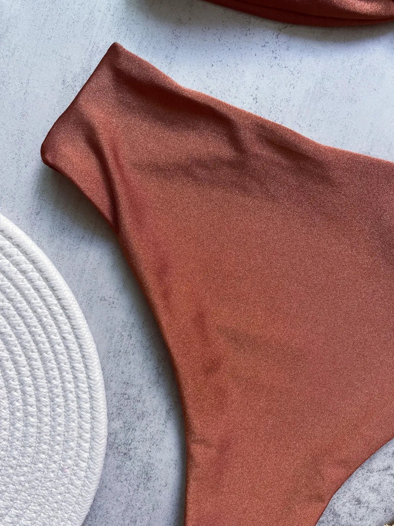 Bandeau bikini top in rust orange satin-like fabric; solid beachwear