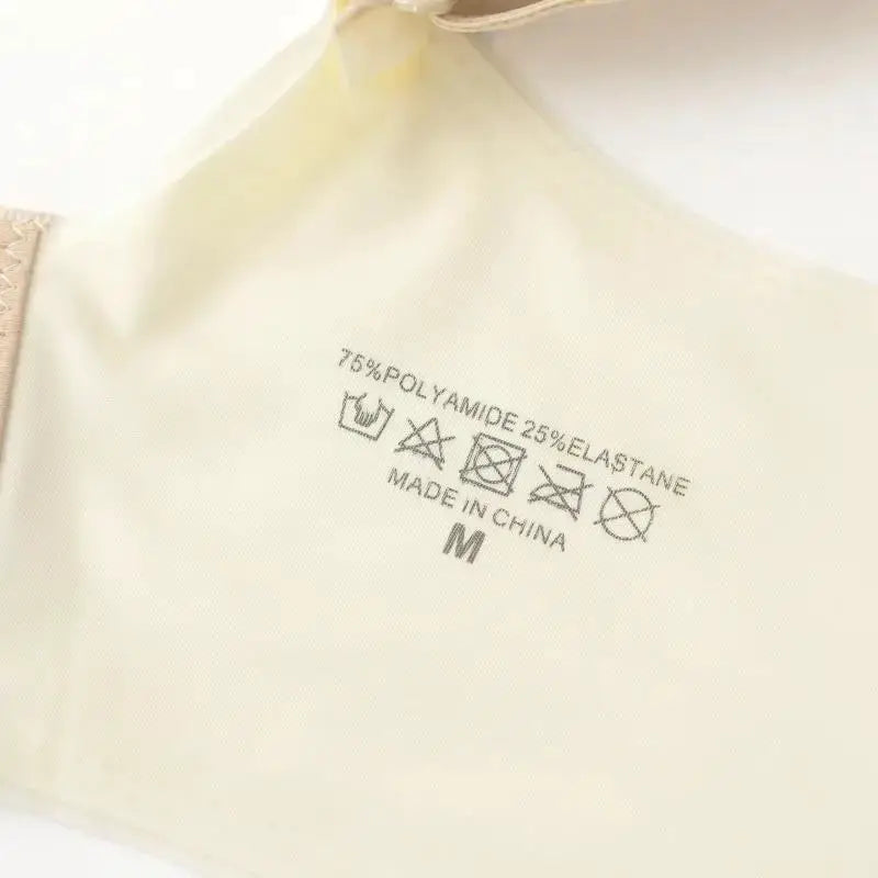 Cream women's bra interior label showing 75% polyamide, 25% elastane, Made in China, size M