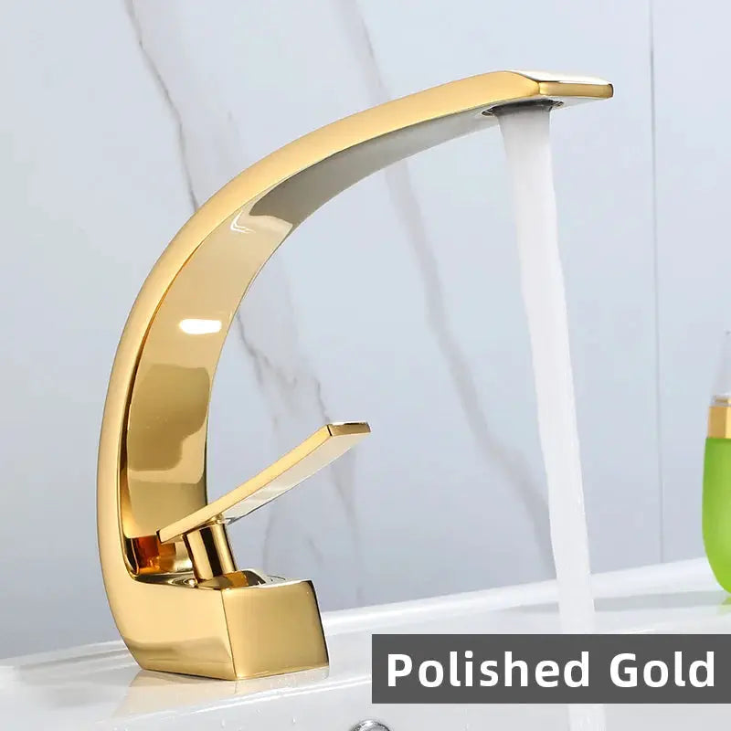 Basin faucet with polished gold finish and curved arch design.