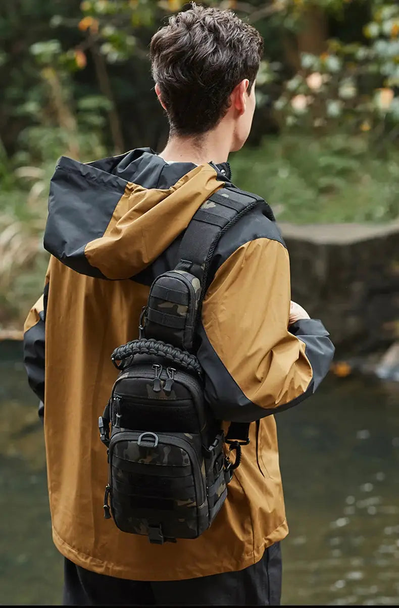 Tactical chest bag with MOLLE pouches, black camouflage, Simples Market, worn by man in outdoor gear.