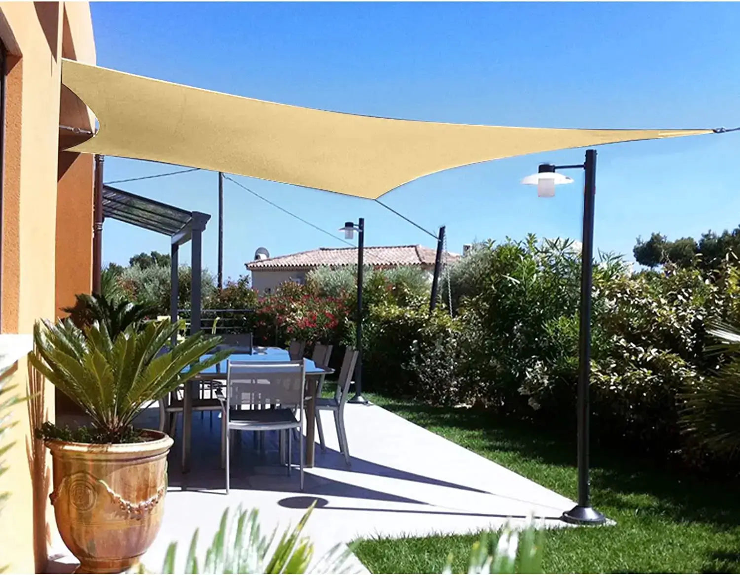 Waterproof sun shade sail canopy rectangle in beige over an outdoor patio dining area with black posts