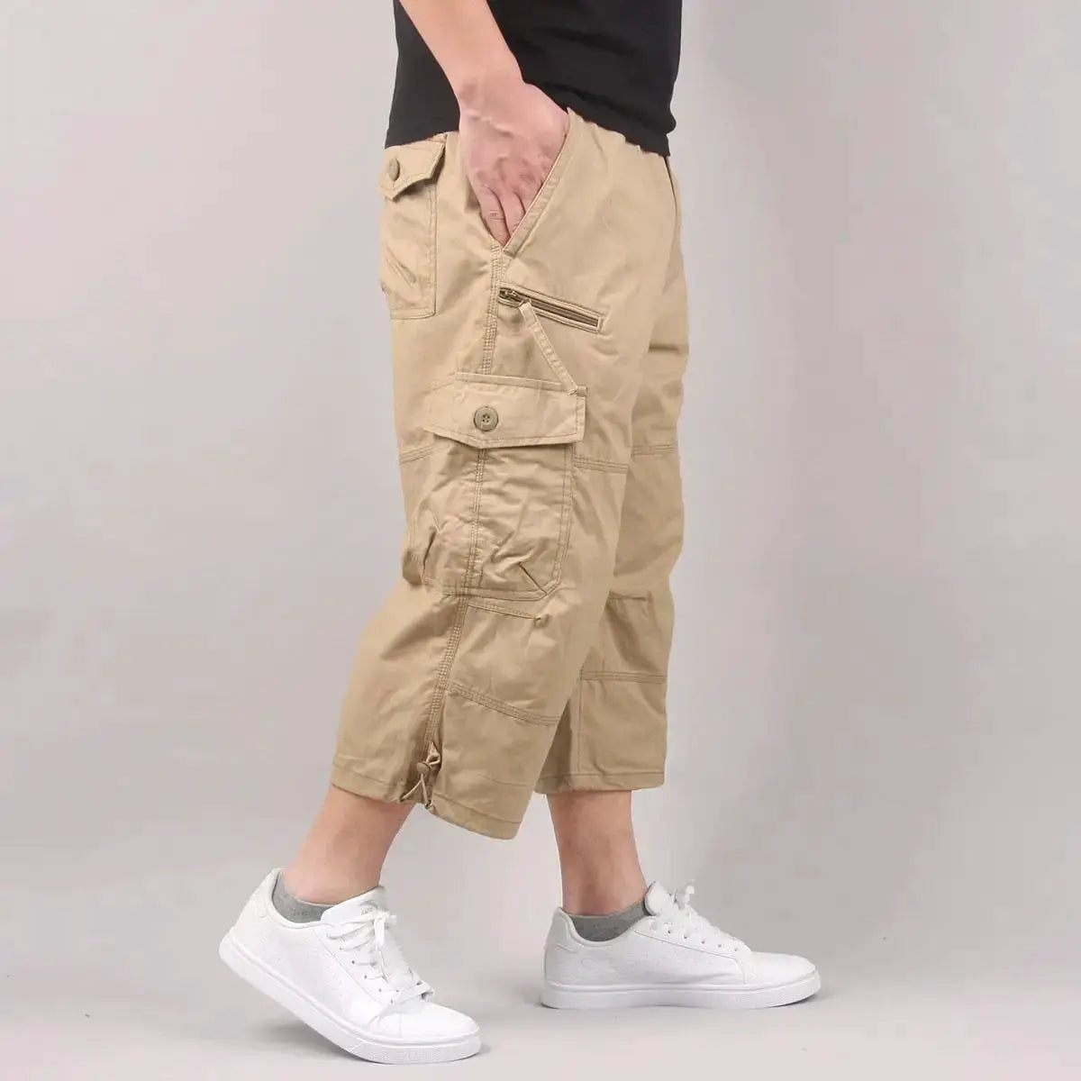 Men's khaki cargo shorts with elastic waist and multiple pockets, including zippered side pocket.