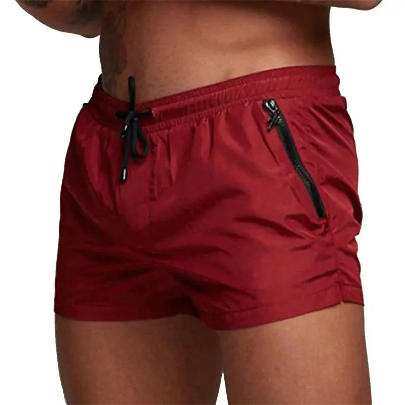 Men's red swim trunks with black drawstring and zippered side pockets by Simples Market