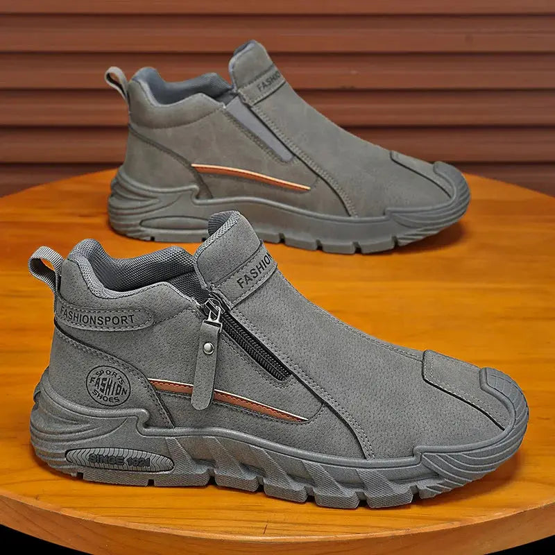Men's gray hiking shoes with side zipper and rugged rubber sole; two shoes on a wooden table
