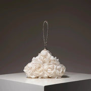 Mini crystal-beaded purse charm with a silver loop, displayed on a white rose bouquet