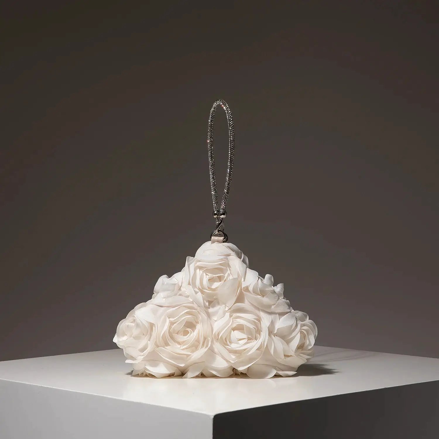Mini crystal-beaded purse charm with a silver loop, displayed on a white rose bouquet