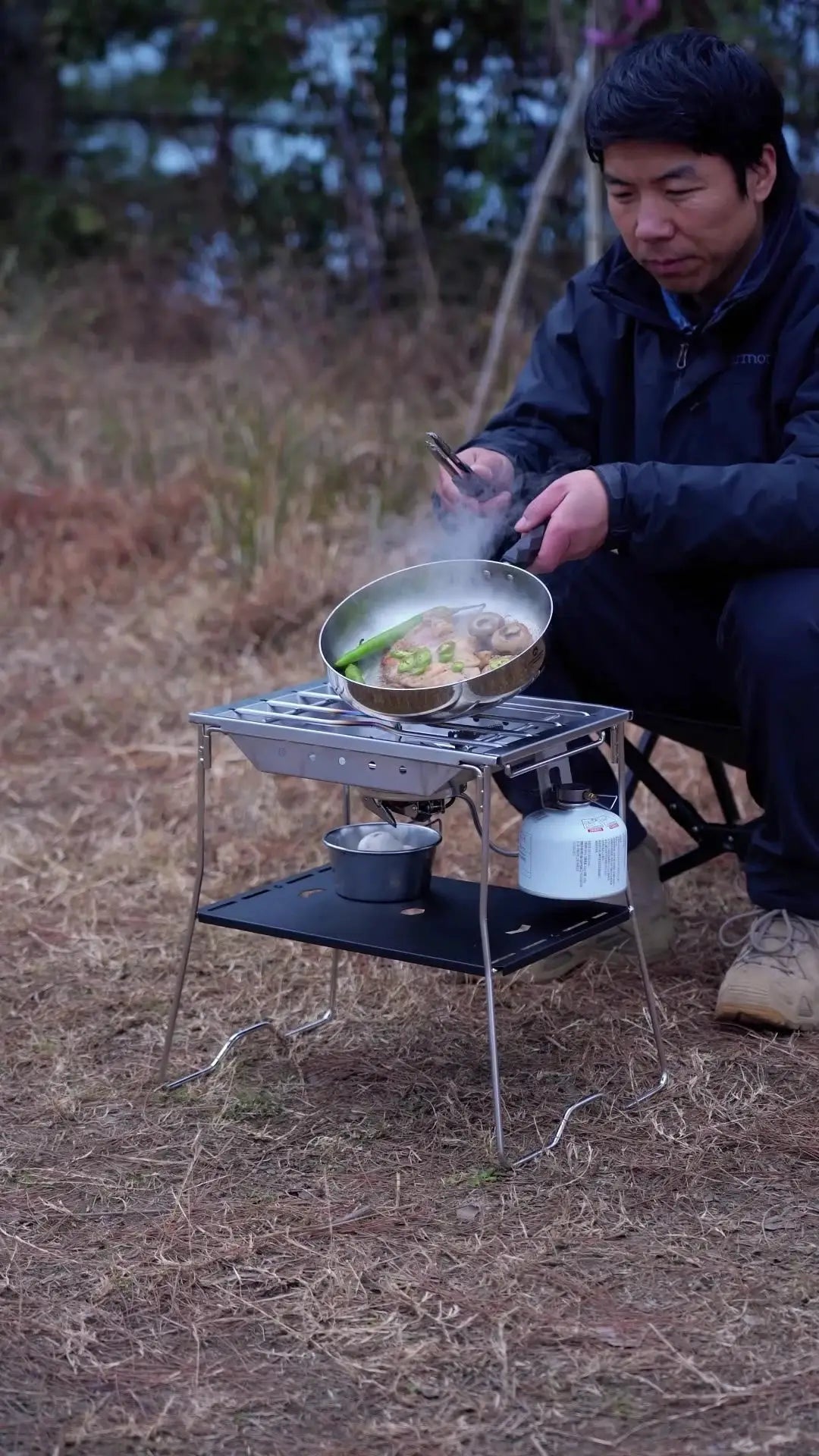 CK-25PG stainless steel camping stove with a frying pan cooking vegetables outdoors on a compact gas burner
