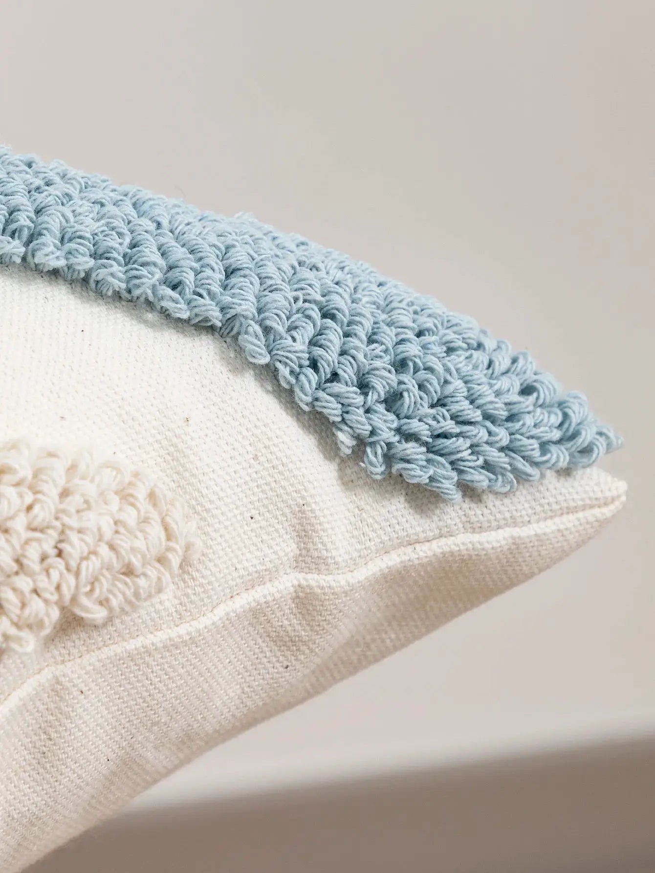 Pillowcase with blue loop velvet edge on cream woven fabric.