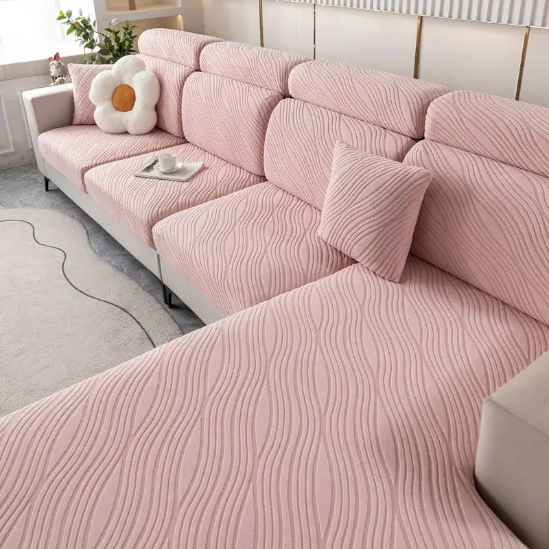 Pink plush sofa cover with elastic edges and wavy texture for living room sectional furniture.