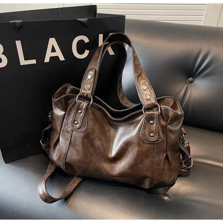Brown PU leather shoulder bag with top handles, zipper closure and rivet details