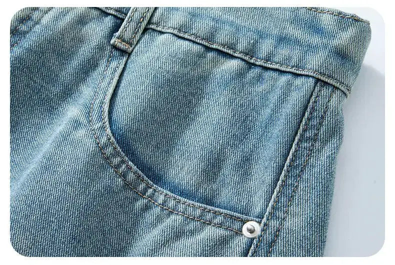 Men's baggy denim shorts in light vintage wash with curved front pocket and rivet.