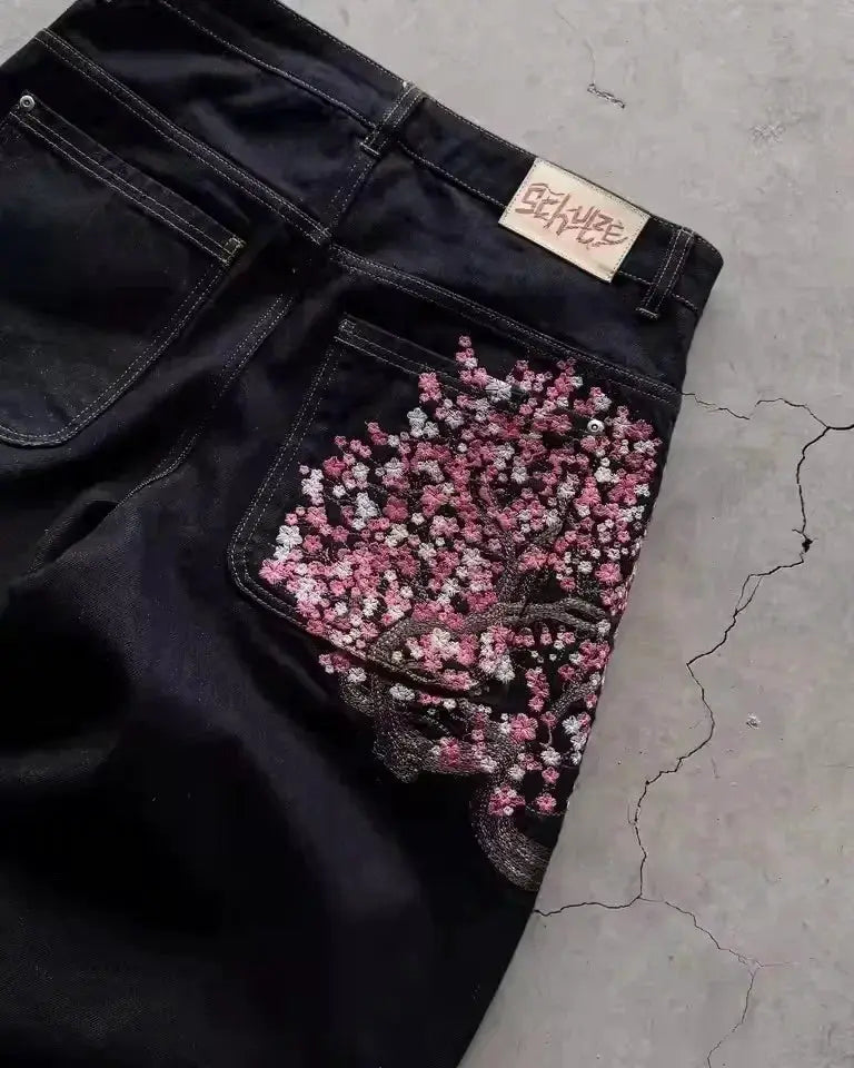 Simples Market black jeans with pink cherry blossom embroidery on back pocket; low-waist, wide-leg pair.