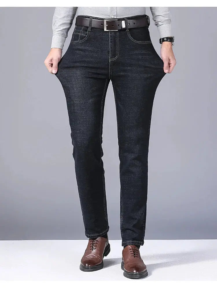 Men's stretch straight jeans in dark denim; slim fit with brown belt and dress shoes.