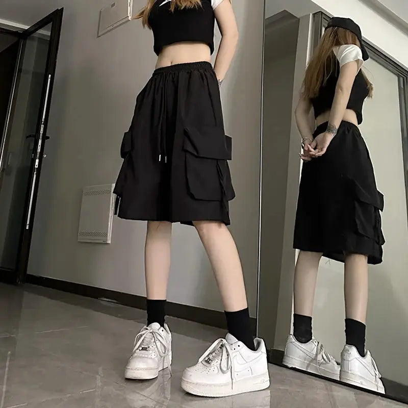 ZOKI women's high-waist cargo shorts in black with large side cargo pockets, knee-length, loose wide-leg fit