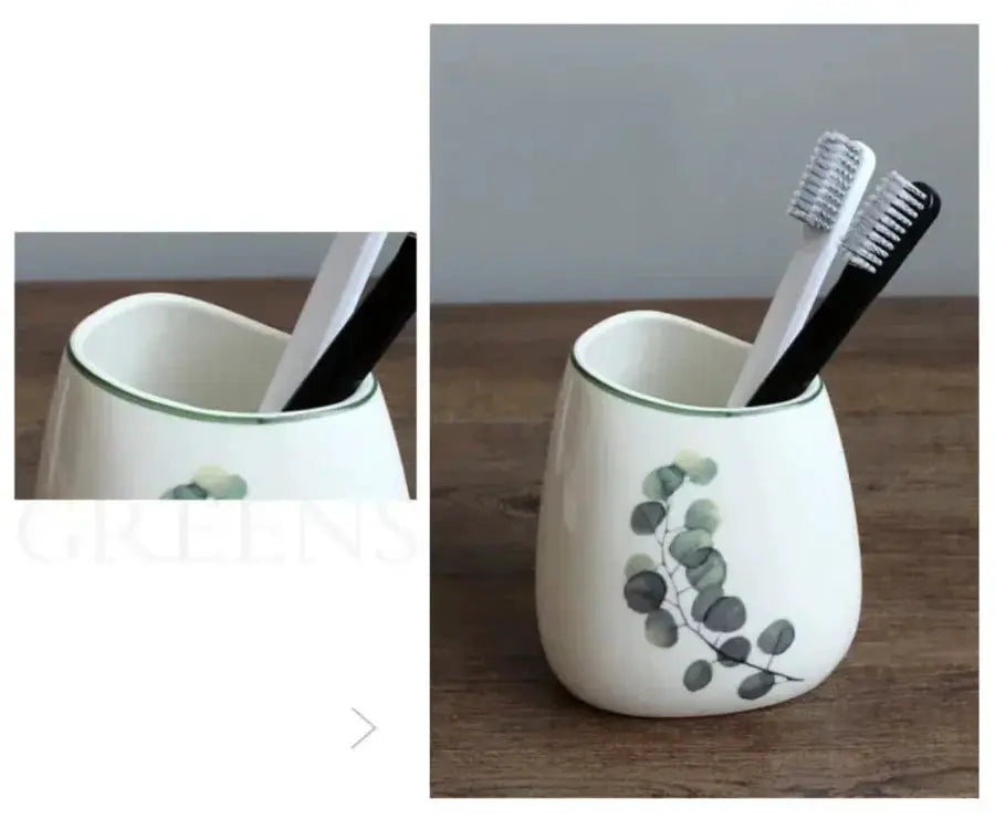 White ceramic bathroom accessory holder with eucalyptus motif, holding two toothbrushes