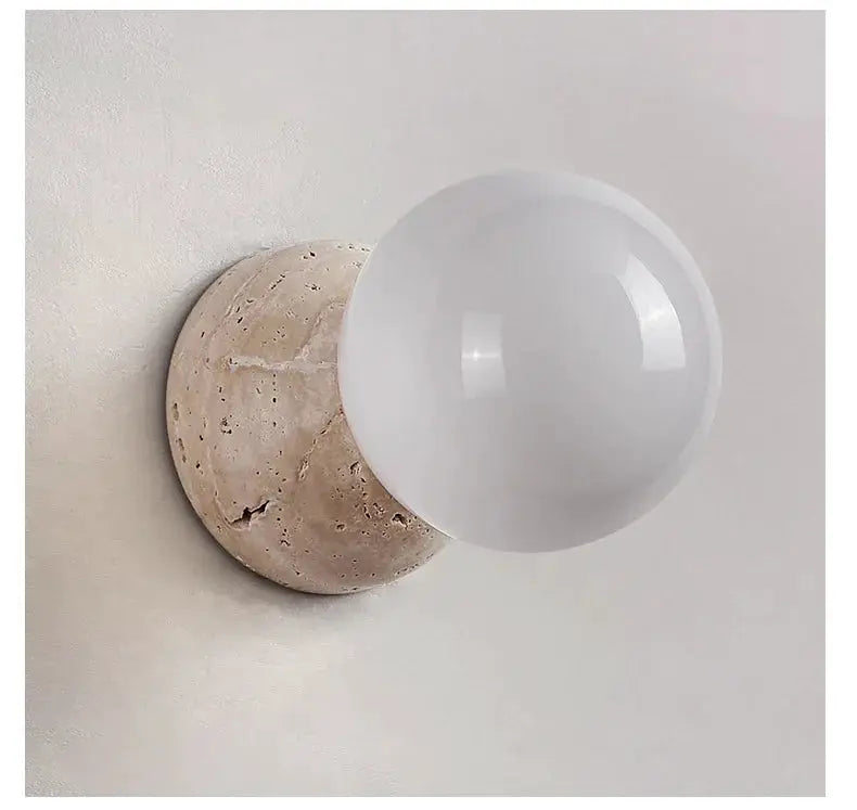 Cream round LED wall lamp by Simples Market with stone backplate and frosted glass globe