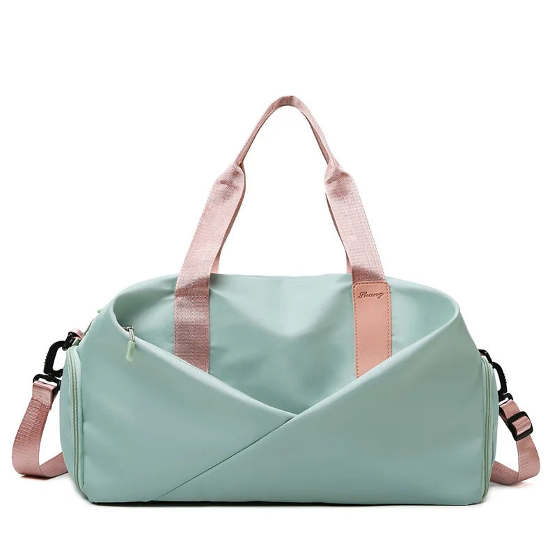 Gym bag in mint green with pink handles and strap, large-capacity fitness travel bag.