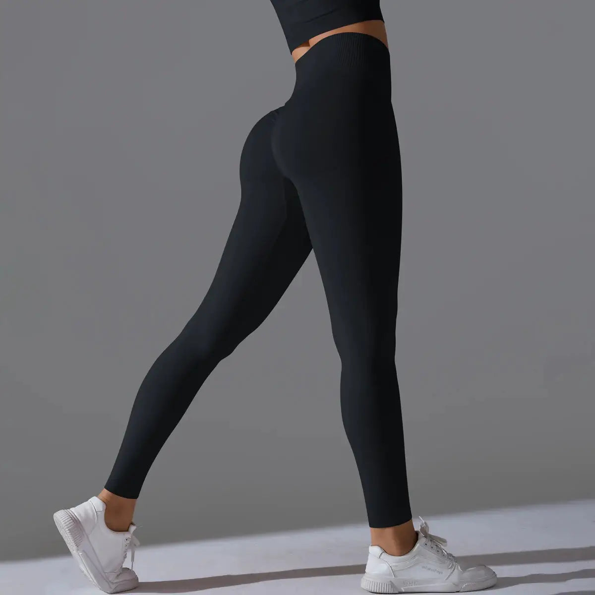 Women's seamless yoga leggings, black high-waist gym pants, model wearing white sneakers.
