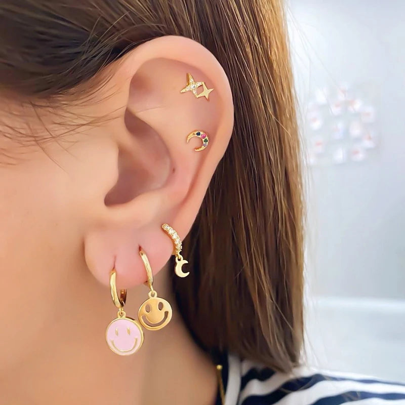 Simples Market gold-tone ear jewelry set with pink smiley pendant hoops and moon/star studs on the ear