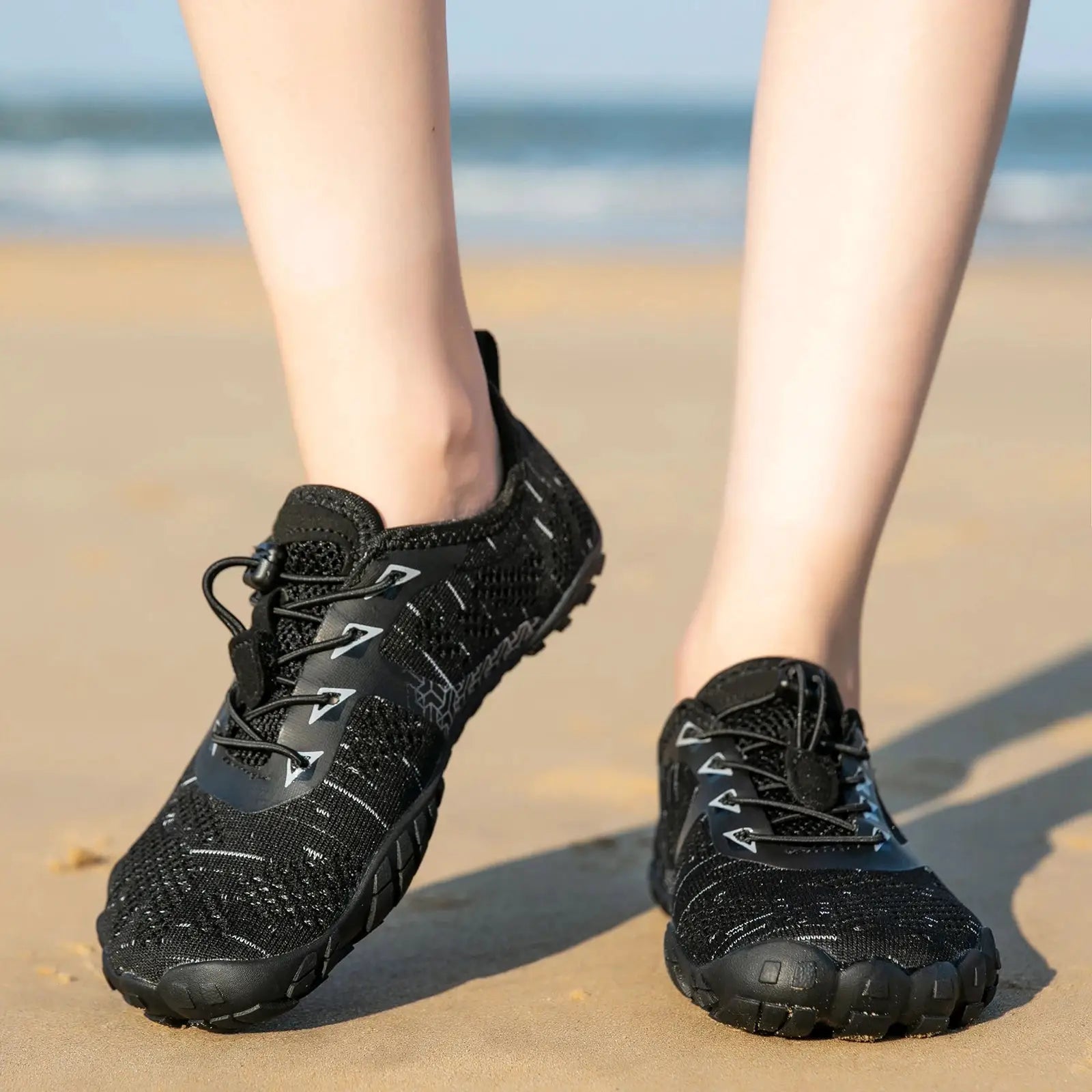 Simples Market men's trail running shoes, black minimalist knit upper, pair on the beach