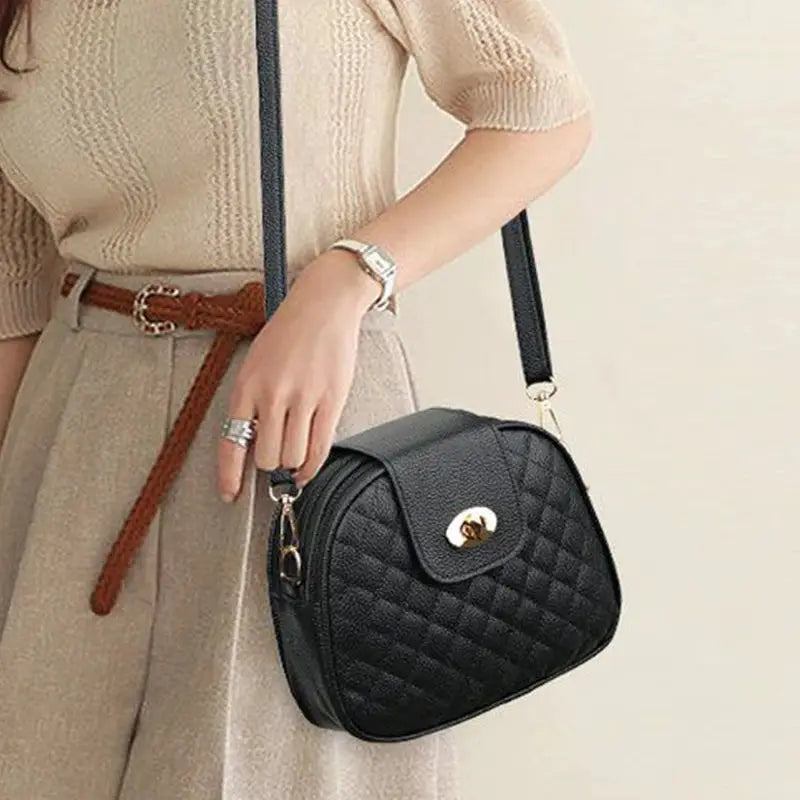 Gentle Compact Quilted Oval Crossbody Bag in black PU leather with gold turn-lock.