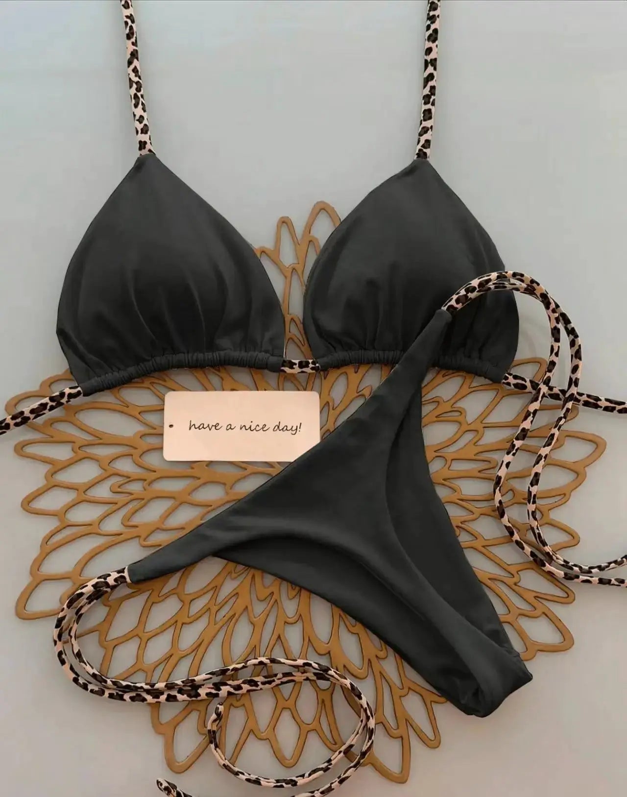 Leopard-print bikini set by Simples Market with black triangle top and thong bottom