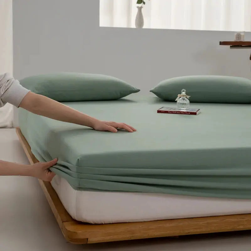 Simples Market soft cotton fitted sheet in sage green with elastic edges on a bed