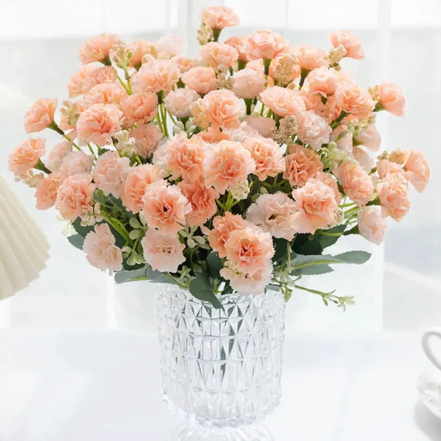 Peach carnations bouquet in a diamond-cut glass vase, lush floral arrangement.