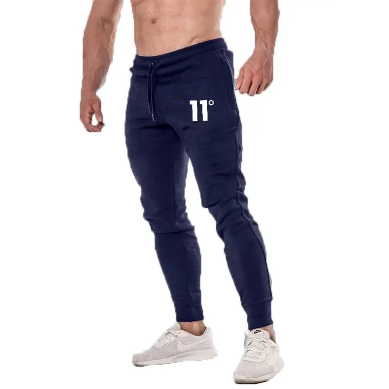 Joggers in navy with drawstring waist, cuffed ankles, featuring white 11° logo.