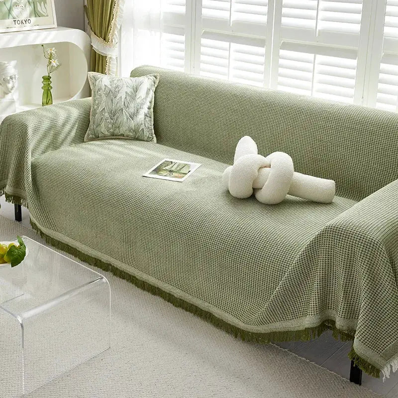 Sofa towel throw by Simples Market in sage green wind-cotton yarn, full-coverage knit with fringe edge