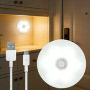 Motion Sensor Light USB Rechargeable Night Light LED Lamp by Simples Market, white round disk.