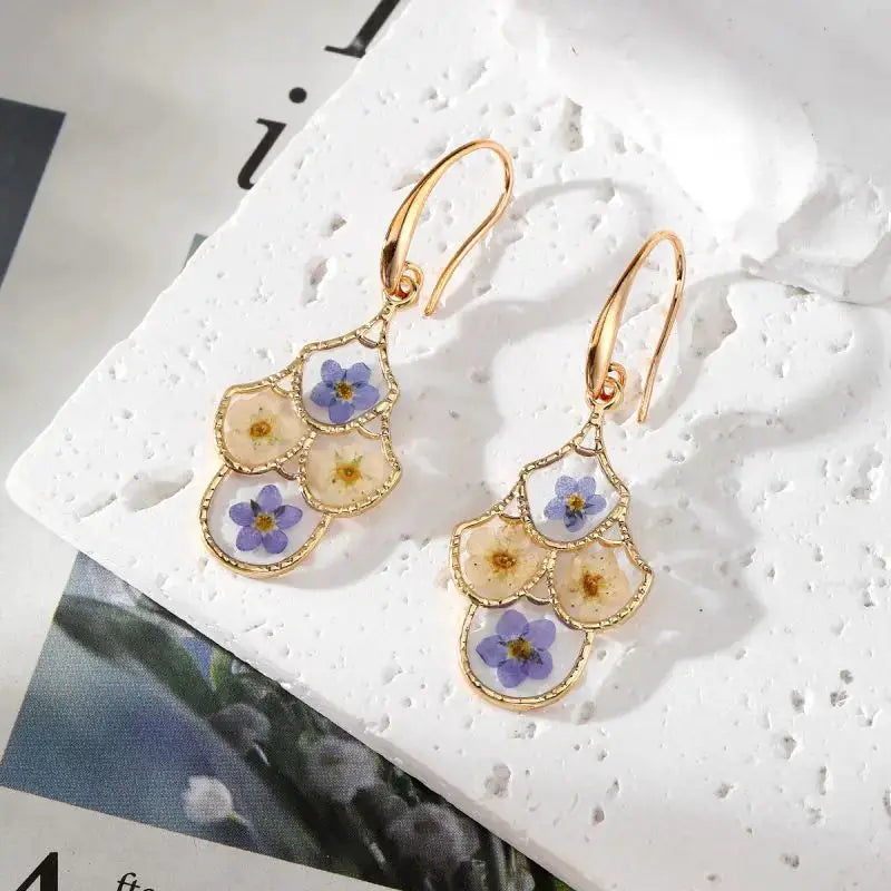 Pair of gold-tone flower dangle earrings with epoxy resin pressed purple and yellow blooms
